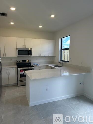 A kitchen with white cabinets and a large island.