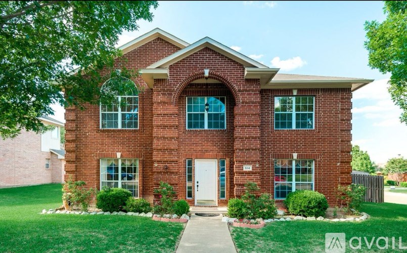 A brick house with a white door and windows.
