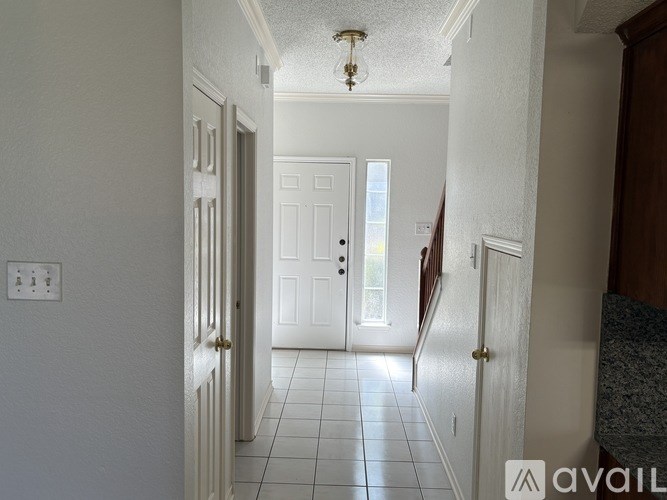 A hallway with a white door and a light on the ceiling.