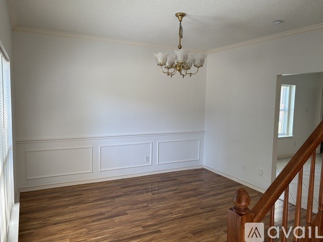 A room with a wooden floor and a chandelier.