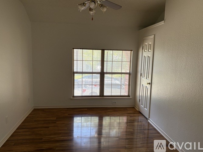 A room with wooden floors and a window with blinds.