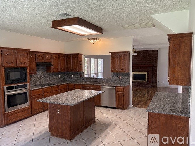 A kitchen with wooden cabinets and granite countertops.