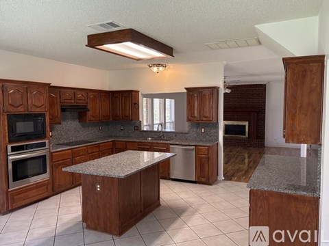 A kitchen with wooden cabinets and granite countertops.