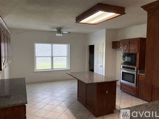 A kitchen with granite countertops and wooden cabinets.
