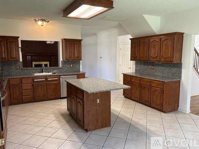 A kitchen with brown cabinets and a granite countertop.