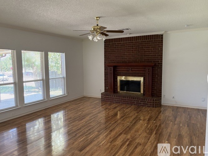 A room with a fireplace and a ceiling fan.