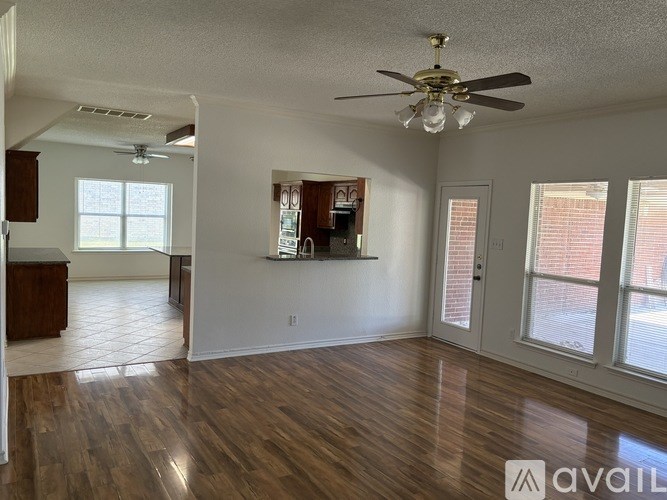 A spacious living room with wood flooring and a ceiling fan.
