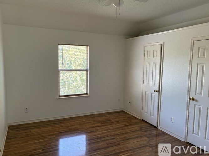 A room with a window and wooden floors is available for rent.