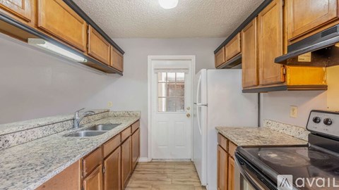 A kitchen with wooden cabinets and granite countertops is available for rent.