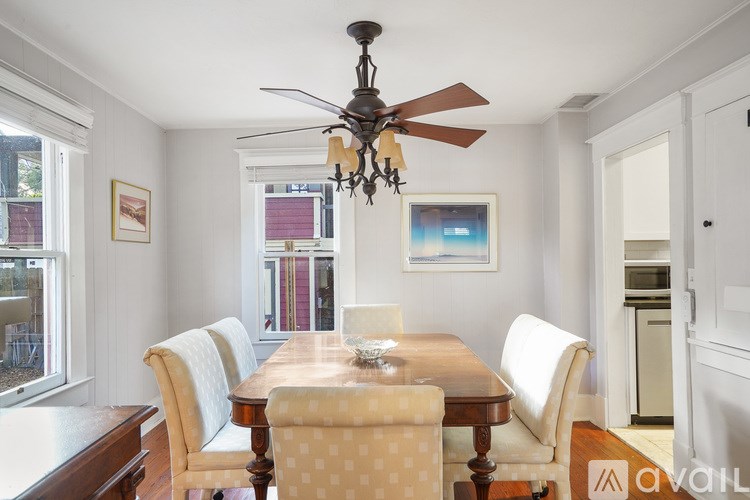 A dining room with a wooden table and chairs.