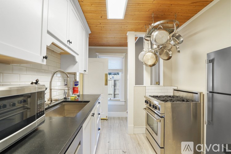 A modern kitchen with stainless steel appliances and white cabinets.