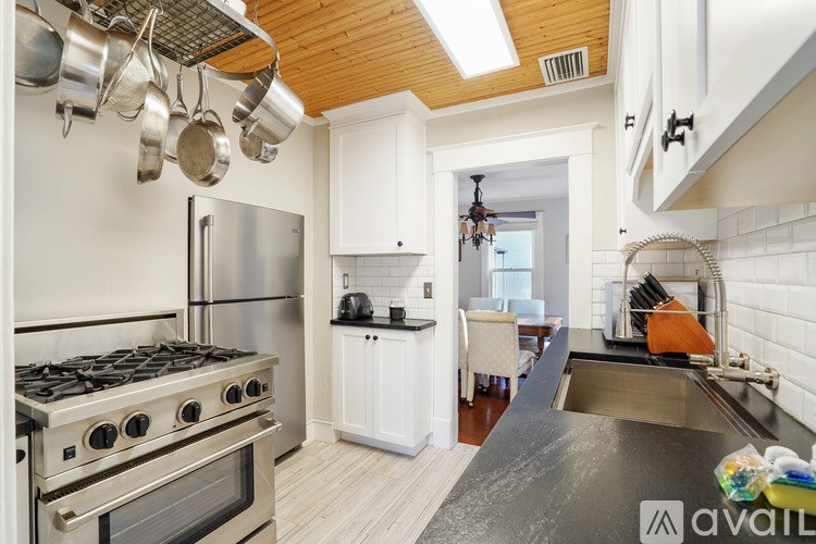 A kitchen with a stove, refrigerator, and a dining table.