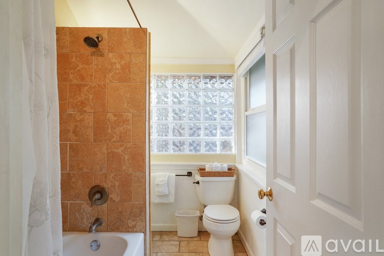 A bathroom with a toilet, sink, and window.