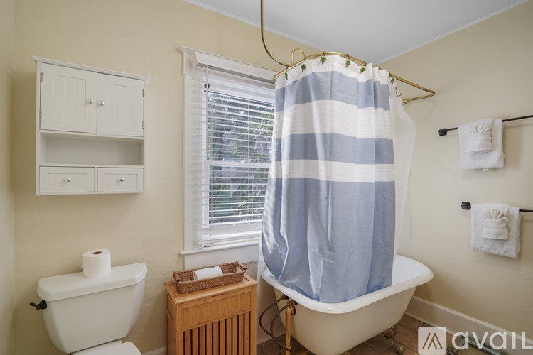 A bathroom with a white tub and a blue and white striped shower curtain.