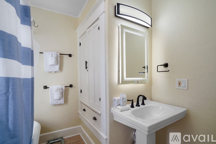 A bathroom with a white sink and a blue and white striped shower curtain.