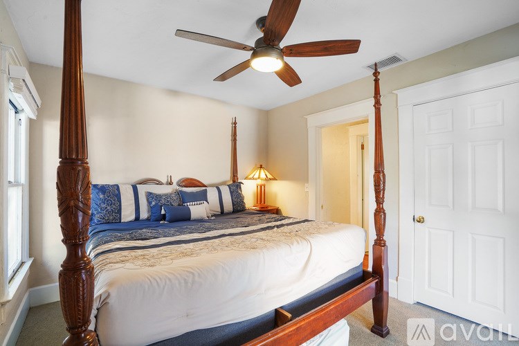 A bedroom with a four poster bed and a ceiling fan.