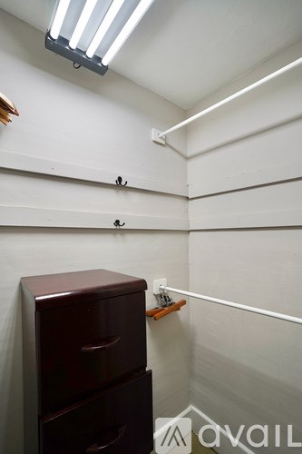 A white wall with a brown cabinet and a light on top.