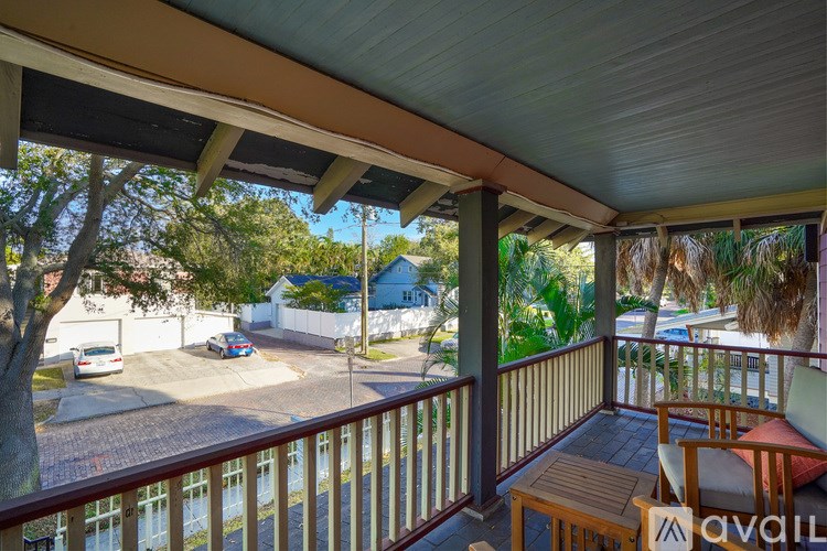 A balcony with a table and chairs overlooking a street.