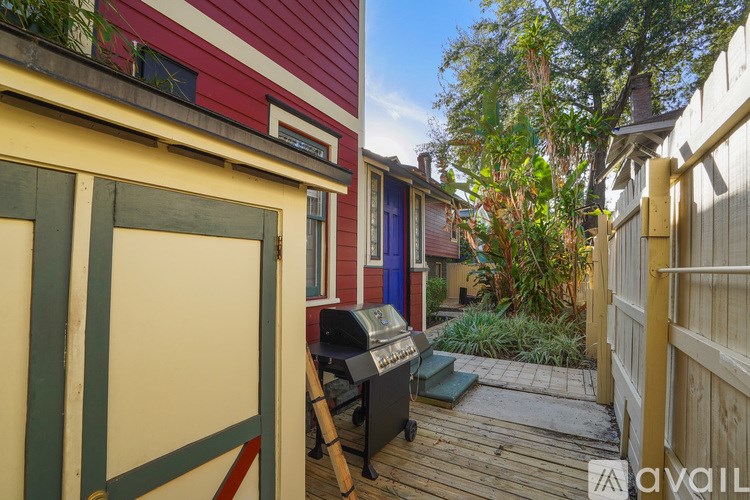 A red and yellow building with a mailbox and a wooden deck.