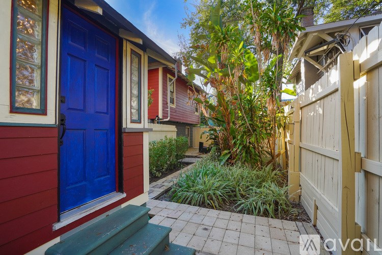 A red house with a blue door and a green step.