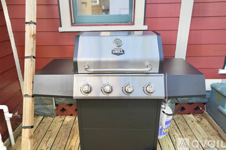A charcoal grill is placed on a wooden deck.