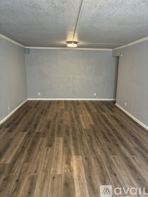 A room with wooden flooring and a white ceiling.
