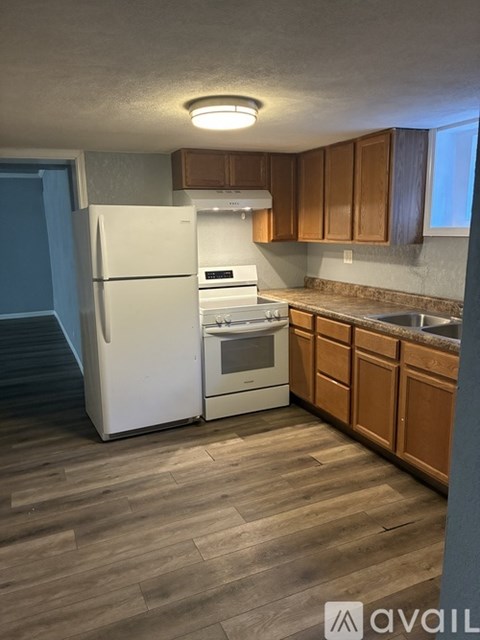 A kitchen with a white refrigerator and wooden cabinets.