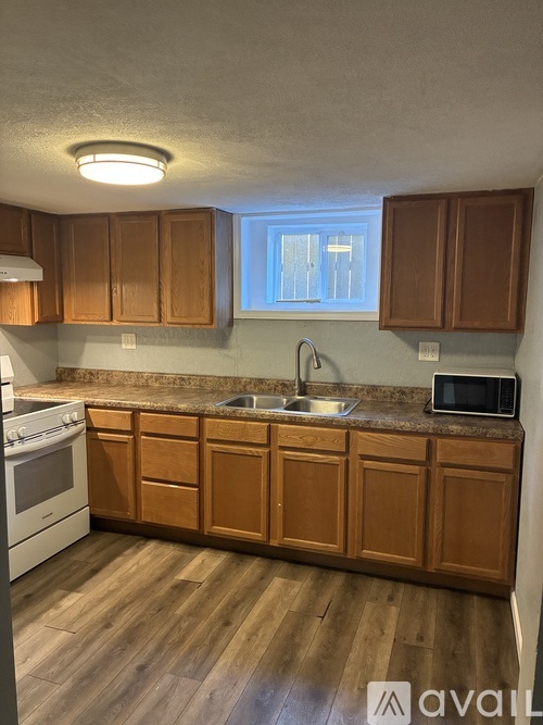 A kitchen with wooden cabinets and a white stove top oven.
