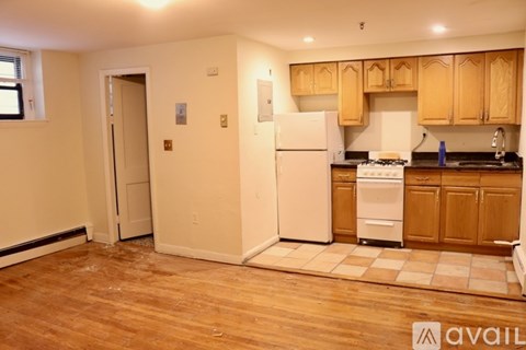 A kitchen with wooden cabinets and a white fridge.