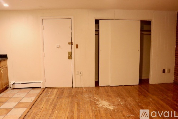 A room with two white doors and wooden floors.