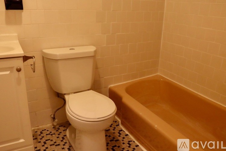 A white toilet sits next to a bathtub in a bathroom.