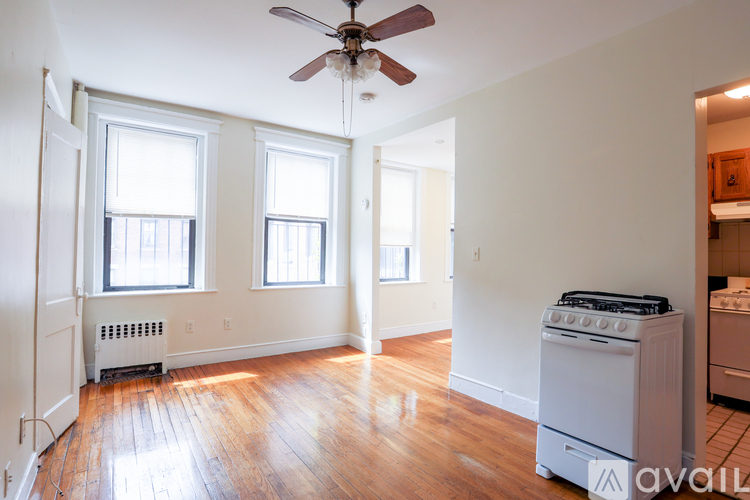 A room with a fan, a stove and a radiator.