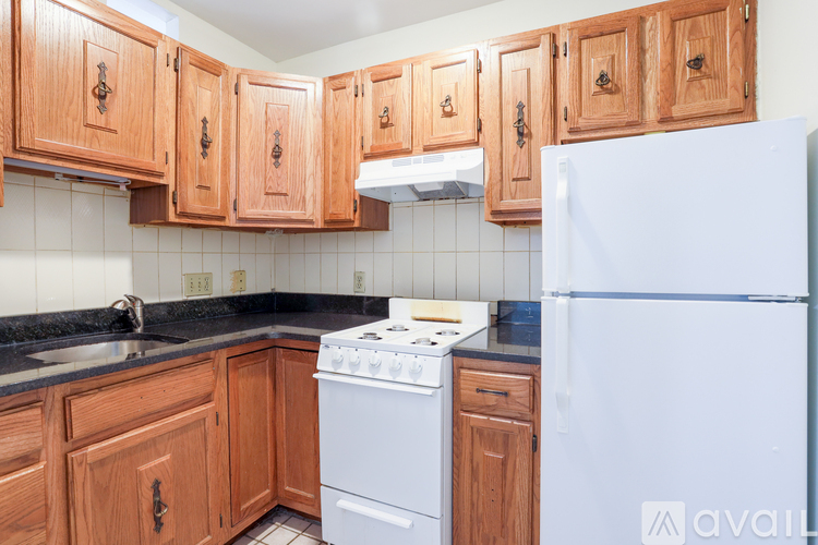 A kitchen with wooden cabinets and a white refrigerator.
