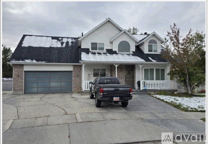 A house with a black truck parked in front.