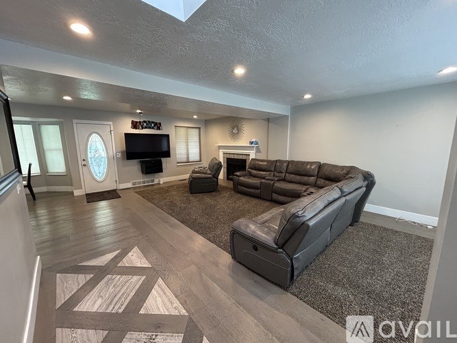 A living room with a couch, a chair, and a television.