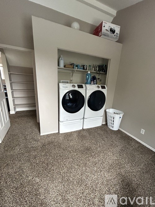 A laundry room with two washing machines and a basket.