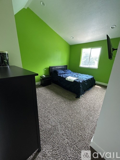 A bedroom with a bed, dresser, and window.