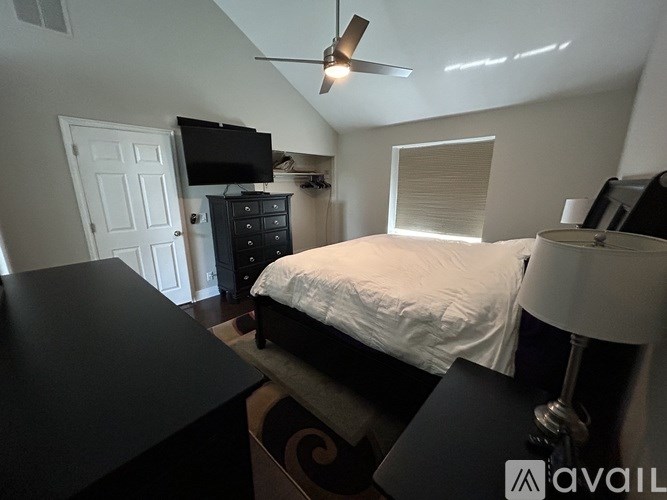 A bedroom with a bed, dresser, and television.
