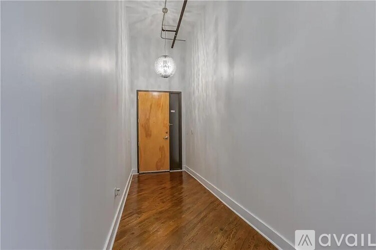 A long hallway with a wooden door at the end.