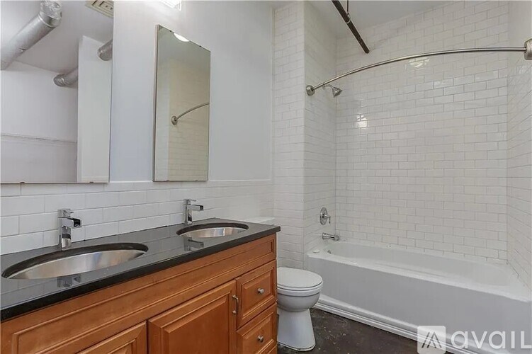 A bathroom with a black countertop and white tiles.