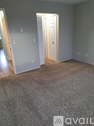A room with a carpeted floor and a white door.