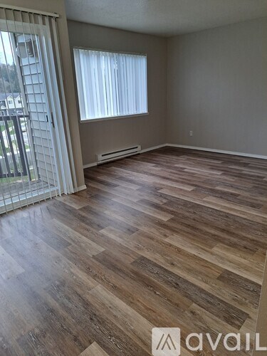 A room with wooden flooring and a sliding glass door.