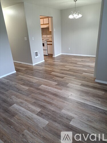 A room with wooden flooring and a chandelier.