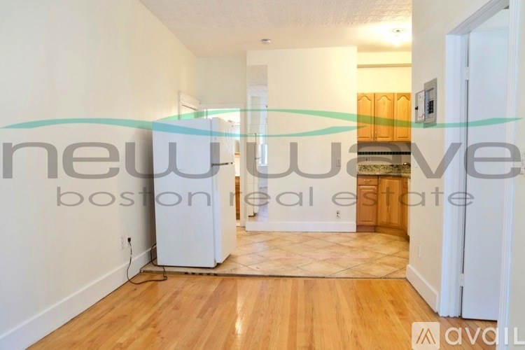 A room with wooden flooring and white walls is available for rent.