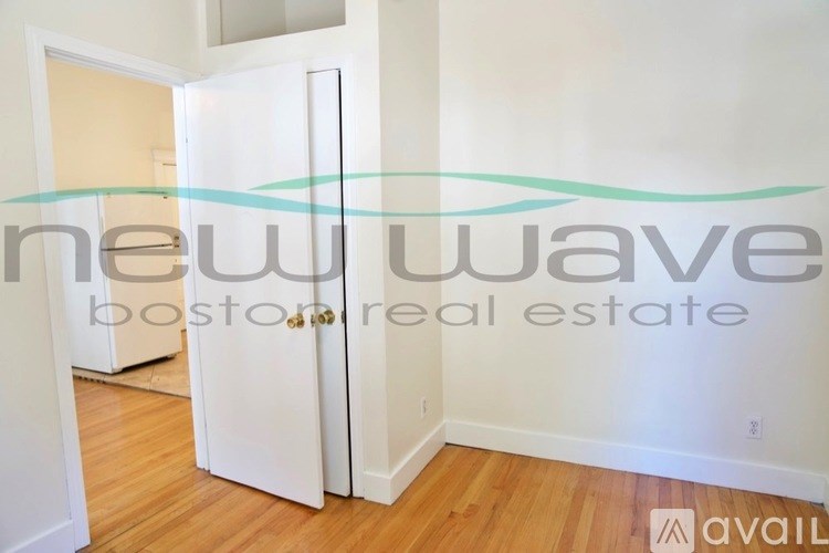 A room with a white door and a sign that says "new wave boston real estate available".