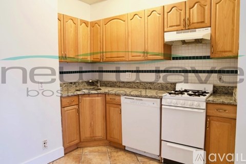 A kitchen with wooden cabinets and a white stove top oven.