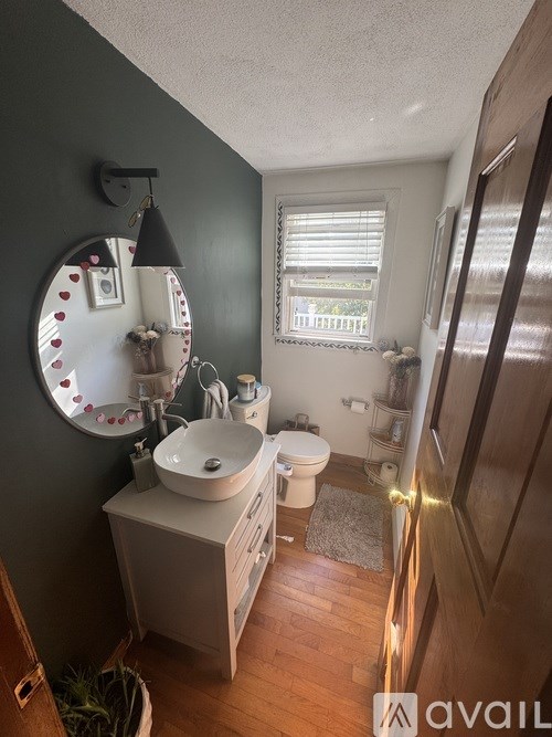 A bathroom with a round mirror and a sink.