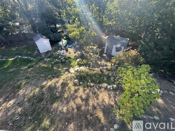 A backyard with a shed and a person sitting on a chair.