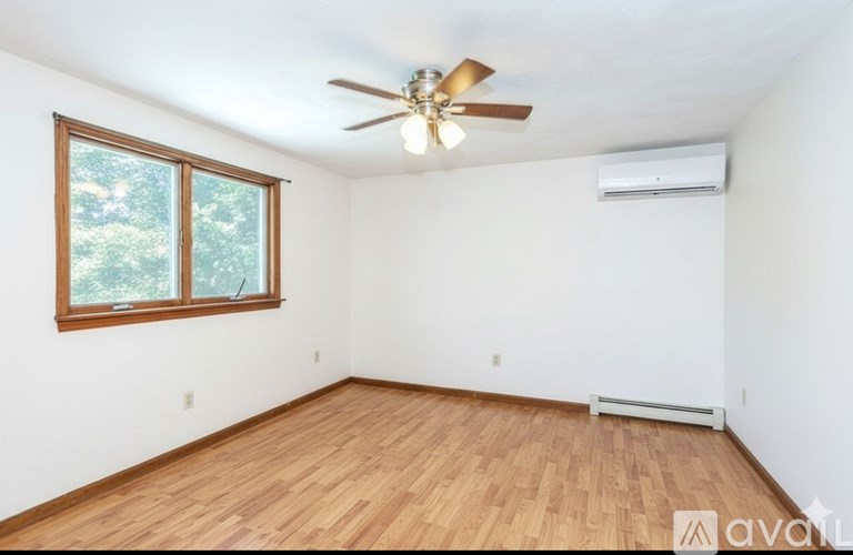 A room with wooden flooring and a ceiling fan.