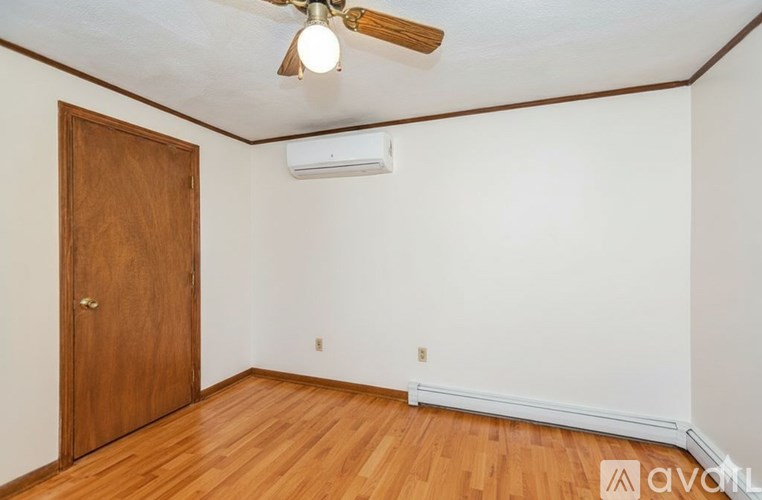 A room with a wooden door and a ceiling fan.
